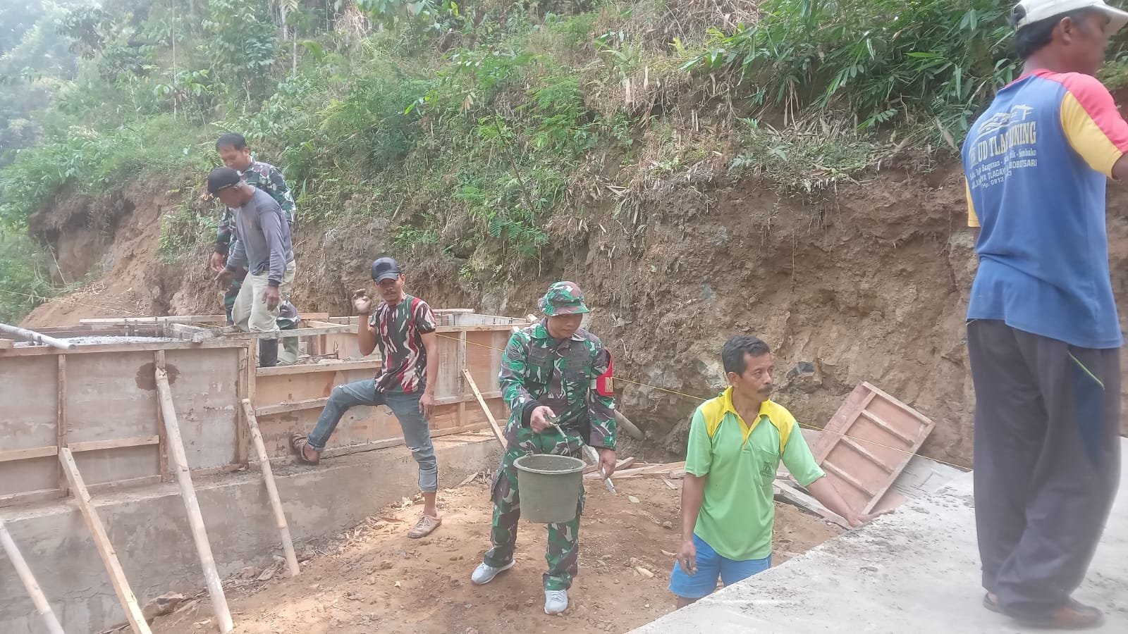 TNI dan Warga Estafet Material Cor Pondasi Jembatan Garuda
