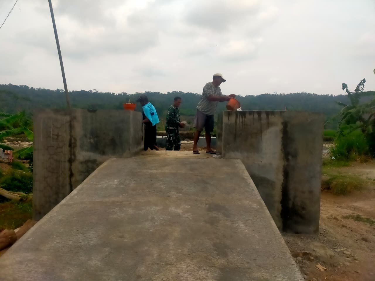 Babinsa dan Warga Siram Air Bangunan Pondasi Jembatan Garuda, Pastikan Bangunan Kuat